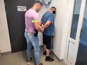policjant zakłada kajdanki mężczyźnie