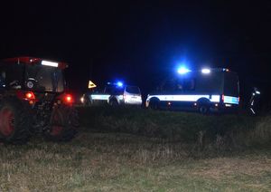 policyjne radiowozy i ciągnik na miejscu wypadku w porze wieczorowej