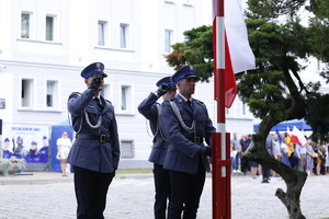 Policjanci z Pocztu Flagowego umieszczają flagę Polski na maszcie.