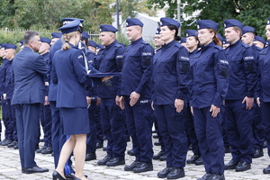 Komendant Wojewódzki Policji w Lublinie wraz z Wojewodą Lubelskim Lechem Sprawką wręcza legitymacje nowemu policjantowi.