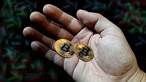 na dłoni pieniądze bitcoiny