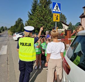 policjantka z dziećmi przy przejściu dla pieszych
