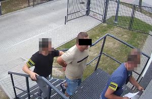 kryminalni prowadzą po schodach mężczyznę