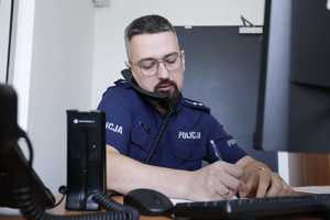 policjant przy biurku z komputerem