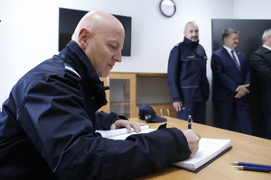 Komendant Główny Policji generalny inspektor Jarosław Szymczyk wpisuje się do księgi pamiątkowej.
