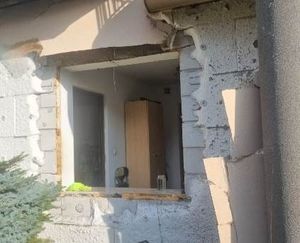 uszkodzona elewacja budynku oraz okno