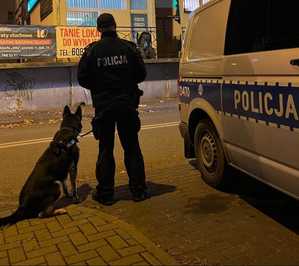 policjant z psem stoją przy placówce banku