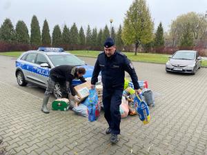 policjant i pracownik schroniska noszą dary