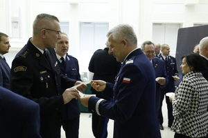 Komendant Wojewódzki Policji w Lublinie nadinspektor Artur Bielecki dzieli się opłatkiem z funkcjonariuszem Straży Pożarnej.