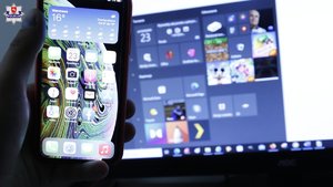 smartfon na tle ekranu komputera z aplikacjami