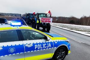 radiowóz na tle protestujących rolników