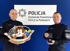 policjanci trzymają przedmioty wystawione na licytację