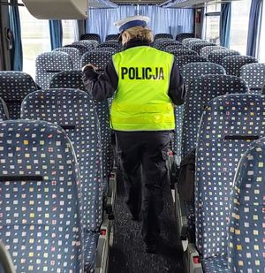 policjantka sprawdza wyposażenie autokaru