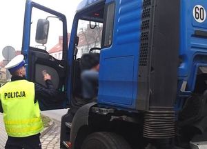 policjant kobtroluje ciężarowy pojazd i kierowcę