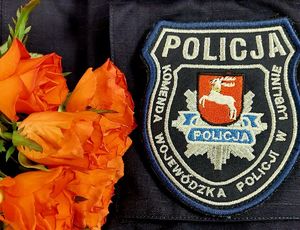 czerwone róże na tle policyjnej kurtki