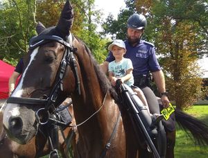 policjant na koniu z dzieckiem