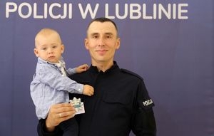 policjant z małym chłopcem na ręku