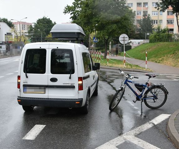 w miejscu zdarzenia, na ulicy stoi zaparkowany samochód i rower