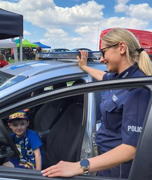 policjantka pokazuje radiowóz dziecku