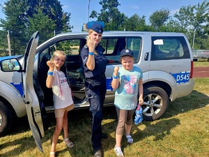 policjantka z dwójką dzieci przy radiowozie