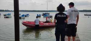 policjanci stoją przy łódce