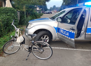 Rower nietrzeźwego rowerzysty oraz oznakowany radiowóz policji.