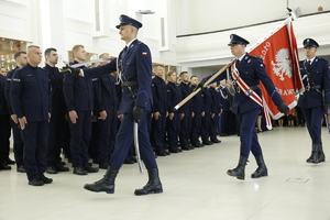 Poczet Sztandarowy Komendy Wojewódzkiej Policji w Lublinie krokiem defiladowym wchodzi na salę w której odbędzie się uroczyste ślubowanie nowych funkcjonariuszy.