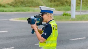 Policjantka mierzy prędkość pojazdom jadącym ulicą Jana Pawła w Lublinie.