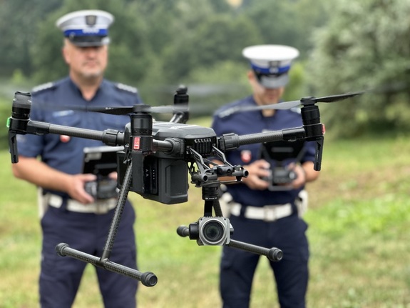 Policjanci pilotują drona.