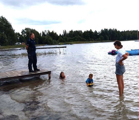 policjant nad jeziorem, w wodzie dzieci
