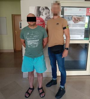 policjant z zatrzymanym mężczyzną