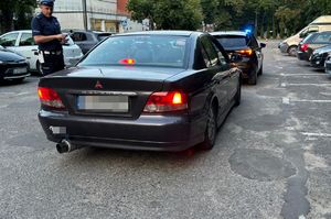 policjant kontroluje samochód Mitsubishi