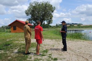 policjantka i ratownicy nad wodą