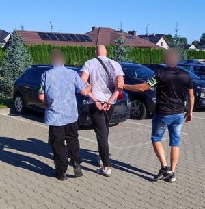 zatrzymany mężczyzna prowadzony przez policjantów