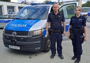 policjant i policjantka przy radiowozie