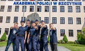 funkcjonariusze stoją przed budynkiem Akademii Policji w Szczytnie