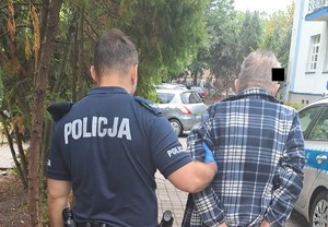 policjant prowadzi zatrzymanego mężczyznę