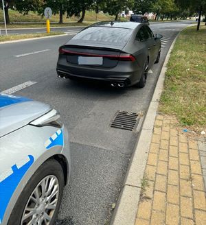 kontrola drogowa pojazdu. Radiowóz i czarny pojazd przed nim.