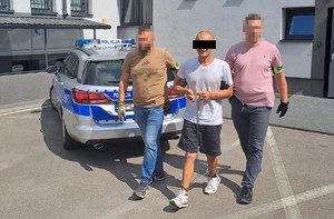 policjanci prowadzą zatrzymanego 27-latka