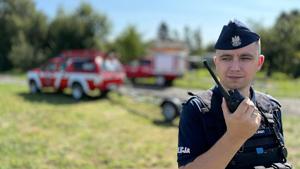 policjant z krótkofalówką podczas dzialań