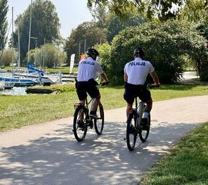 policjanci na rowerach przy zalewie