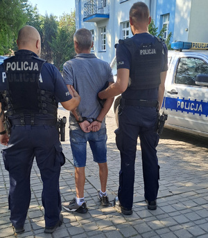 policjanci prowadzą zatrzymanego mężczyznę