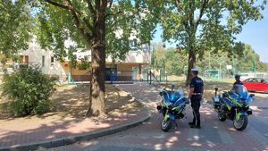 Policjanci na motocyklach w pobliżu szkoły