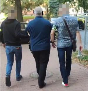 policjanci prowadzą zatrzymanego