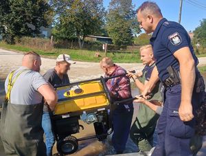 policjanci przekazują agregat prądotwórczy powodzianom