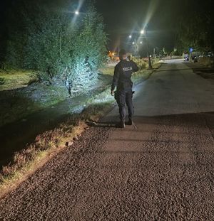 policjant patroluje zalane tereny nocą