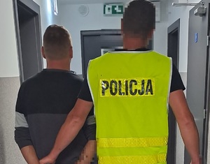 policjant prowadzi zatrzymanego