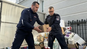 Policjanci ładują do auta dary dla powodzian.