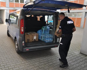 policjant pakuje dary do busa