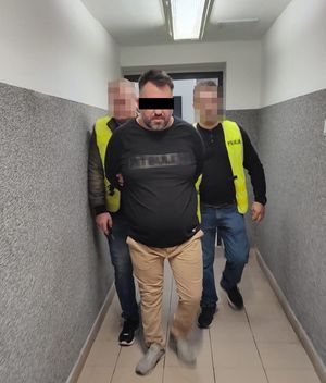 zatrzymany mężczyzna z tyłu dwaj policjanci